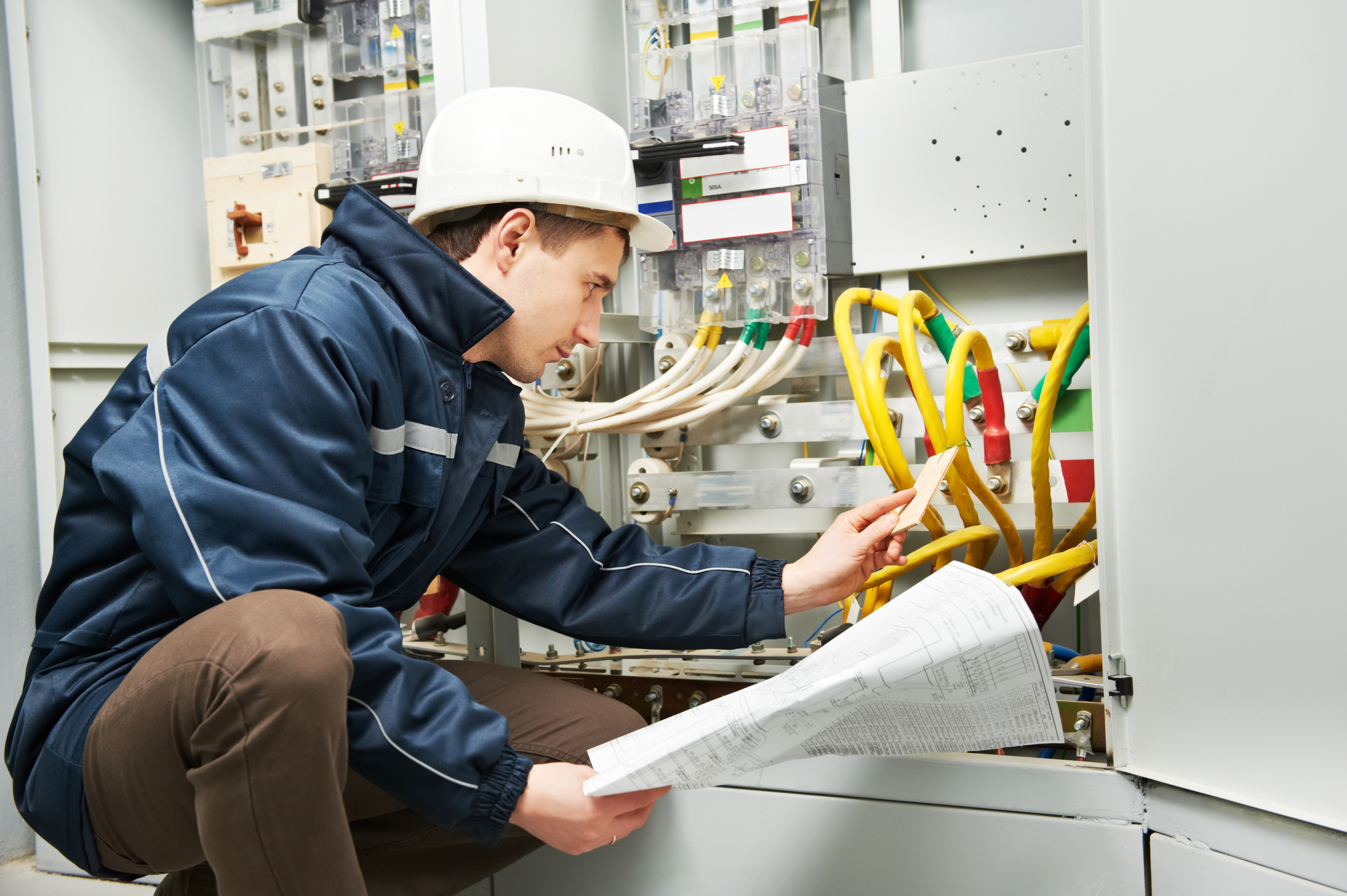 Imagen en la que aparece un trabajador revisando una instalación de cables